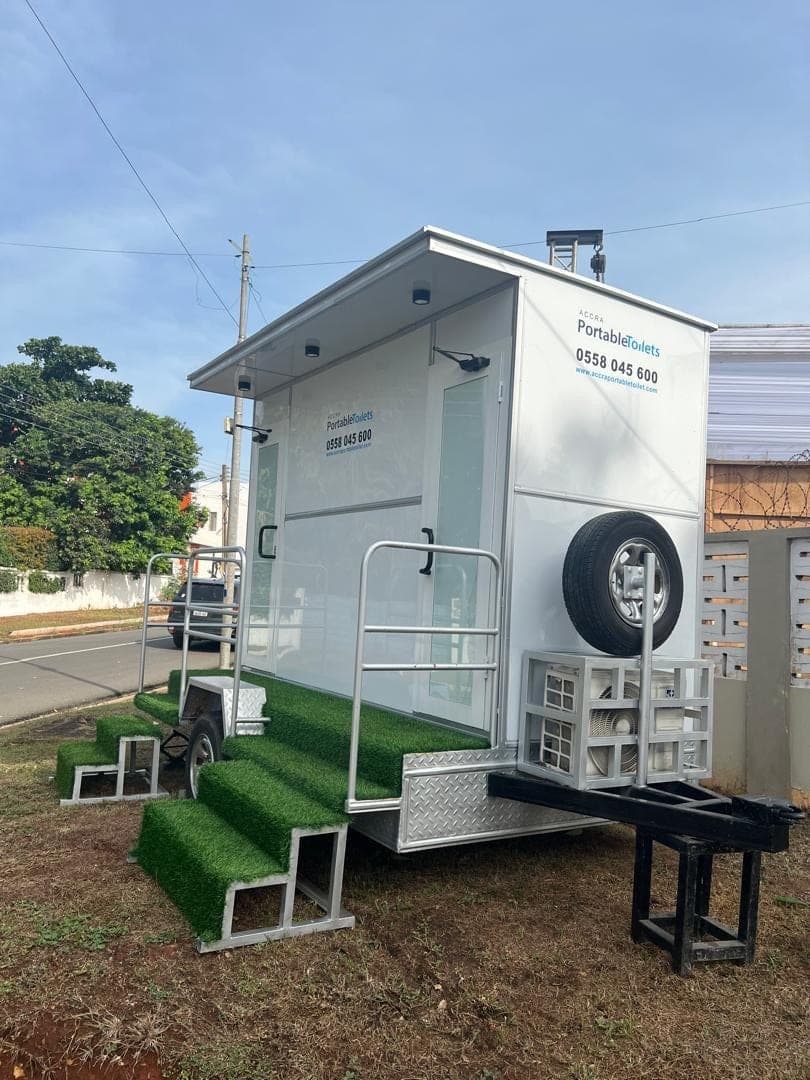 Rear corner of a restroom trailer showing the spare wheel and ventilation units