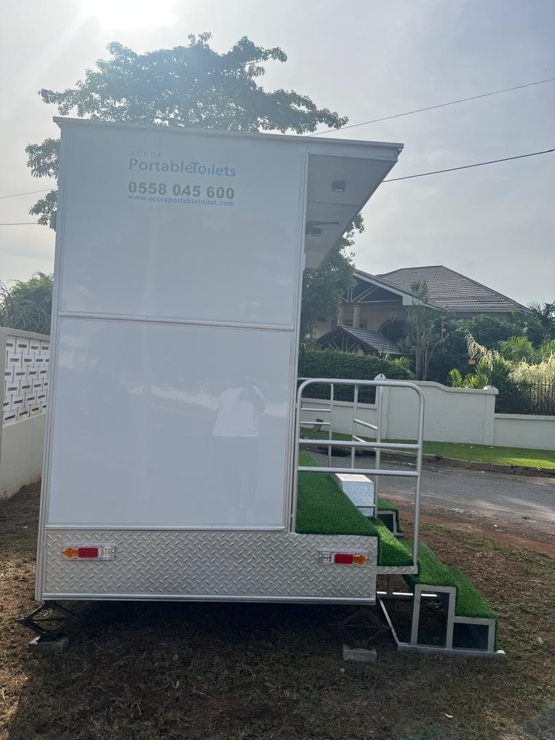 Side view of a closed restroom trailer parked at the roadside