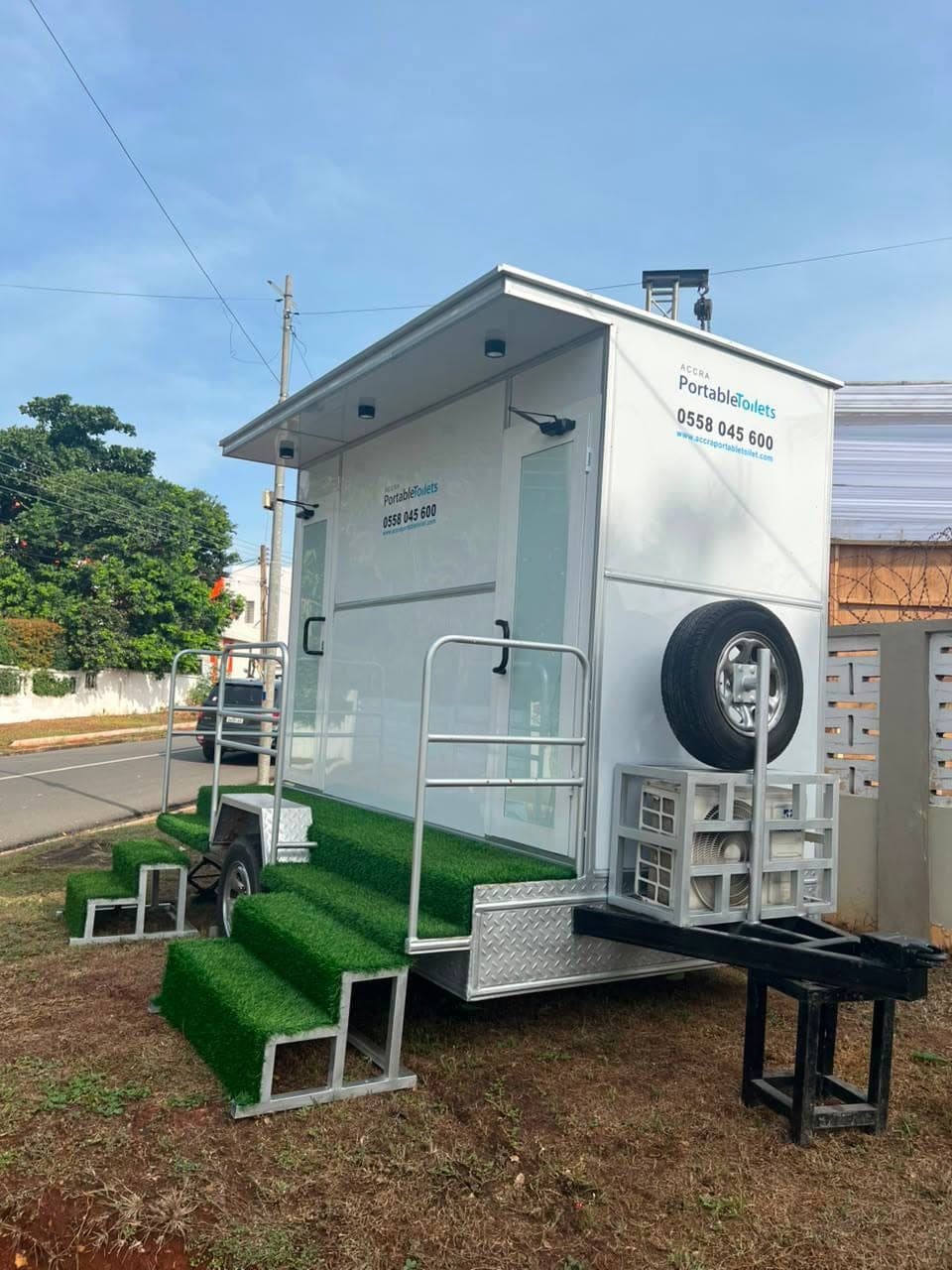 2-door restroom trailer on site, turf steps and handrails in place